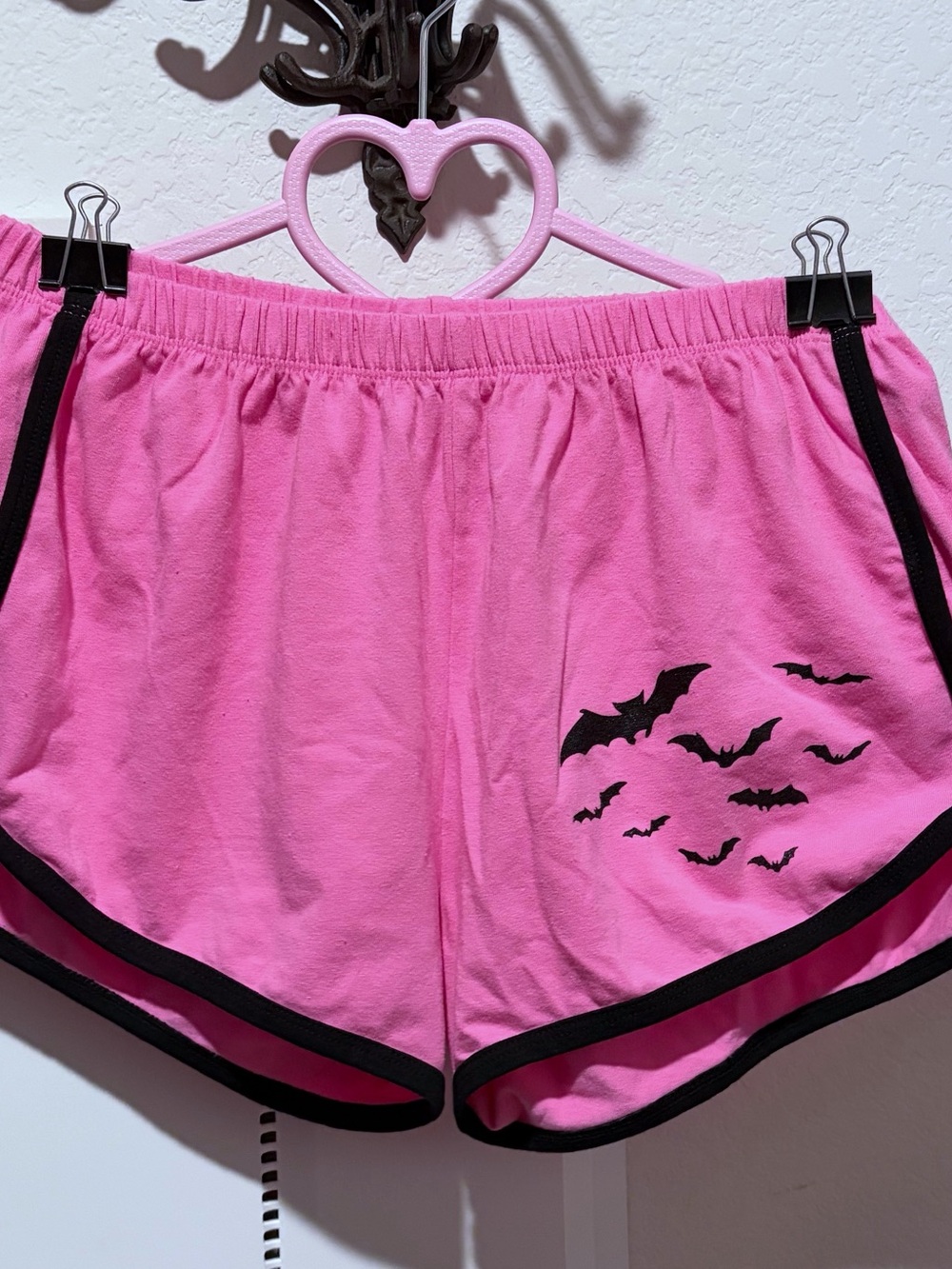 Pink bat dolphin shorts with black trim and elastic waistband. Size: M